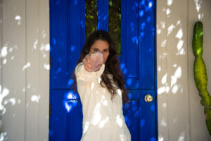 Ilona Barnhart at Four Moons Spa blue door holding a rose quartz