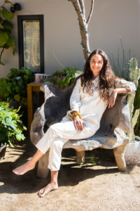 Ilona Barnhart sitting on a wooden chair at Four Moons Spa i n Encinitas California